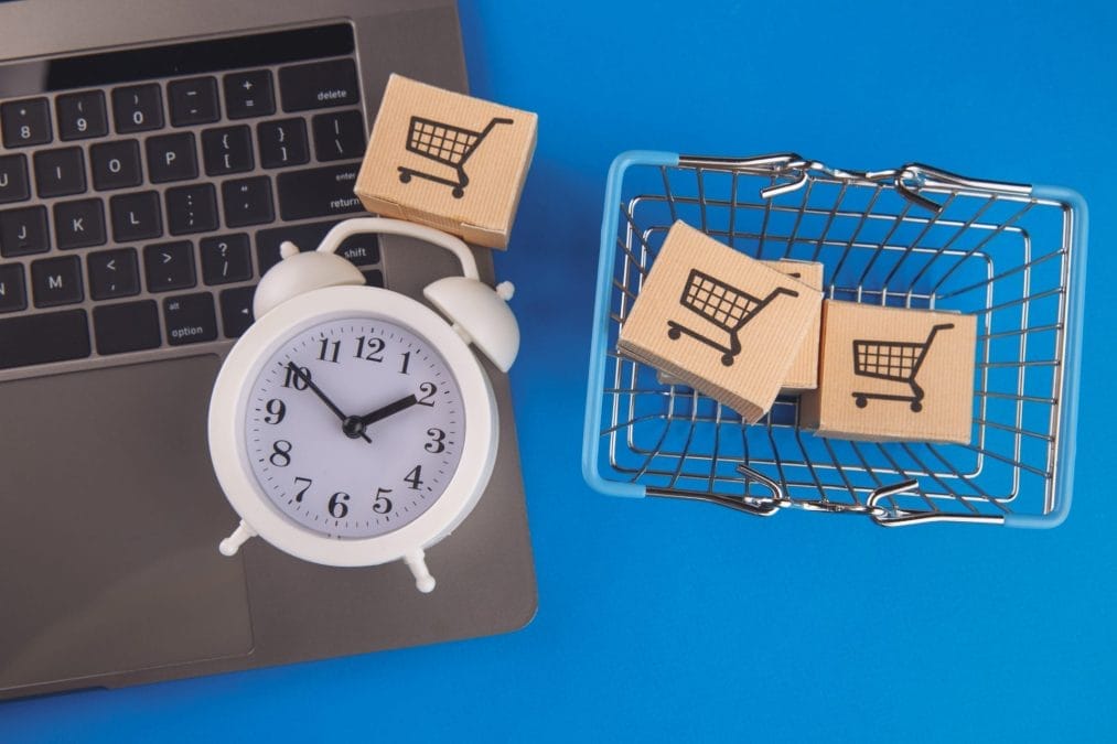 shopping basket with boxes alarm clock isolated blue background